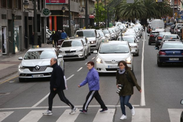 Peatones se cruzan con una manifestación de taxistas. :: juan Marín