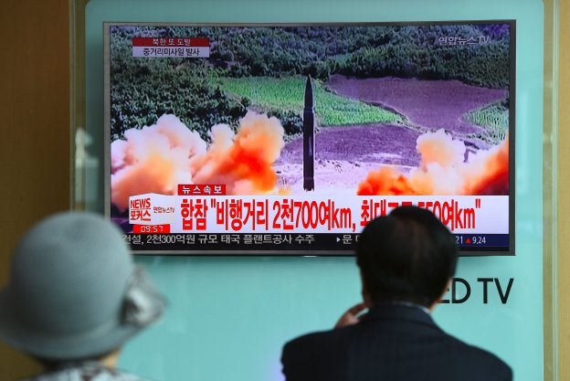 Dos personas observan el lanzamiento del misil. :: JUNG Yeon-Je / afp