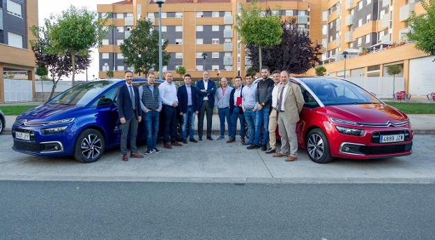 Algunos de los empresarios participantes en la jornada de trabajo, junto a responsables de Auto Iregua, entre dos modelos Citroën . :: /Fernando Díaz