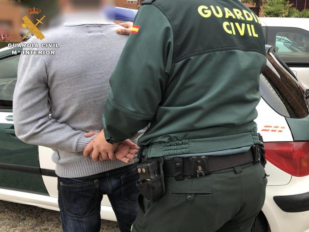 El detenido, conducido por un agente de la Guardia Civil. :: g.c./