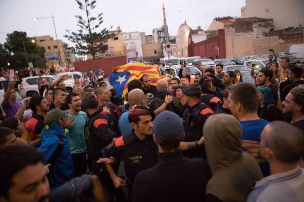 Mossos separan a guardias civiles y manifestantes independentistas durante los disturbios del 1-O en el municipio barcelonés de Calella. :: JORDI BORRAS / afp
/