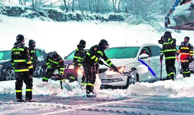 Efectivos de la Unidad Militar de Emergencias (UME) trabajan en la AP-6 para sacar a los vehículos. :: /EFE