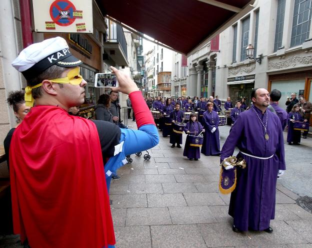 A la izquierda, el desfile del certamen de bandas procesionales a su paso por la calle Capitán Gallarza. A la derecha, un grupo de despedida de soltero atendía al acto. :: JUAN MARÍN/