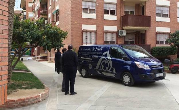 Vehículo de la funeraria en la puerta del inmueble donde ha tenido lugar el presunto crimen. /V. Vicens