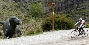 Una réplica de Iguanodón se asoma a la pista del barranco de Peñaportillo, en Munilla. / JUSTO RODRÍGUEZ/