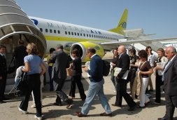 Un grupo de turistas accede a un avión fletado por Opera Romana Pellegrinaggi. / AFP/