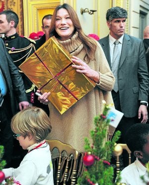 Carla Bruni estuvo entregando regalos sin perder la sonrisa. :: EFE/