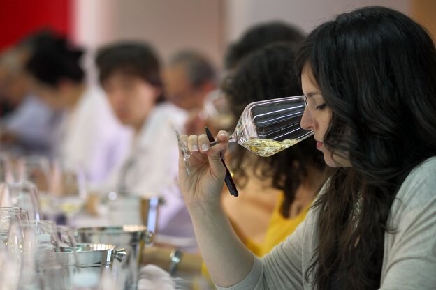Una joven aprecia los olores de un vino durante una cata. 
