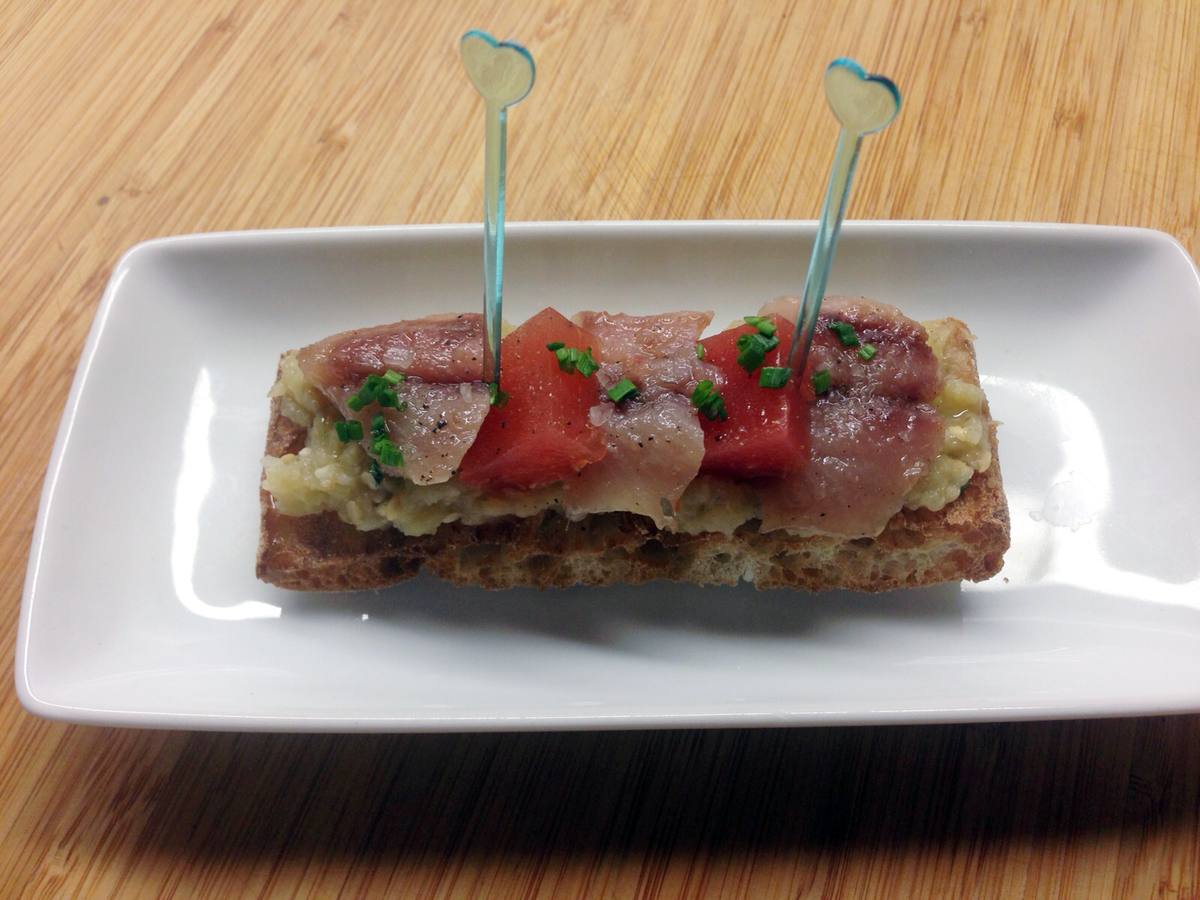 Tosta de sardina ahumada sobre berenjena asada y gelatina de tomate y albahaca