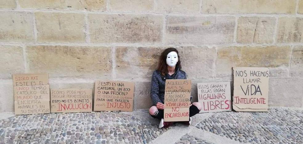 Una mujer protesta junto a la catedral de Santo Domingo contra el encierro del gallo y la gallina