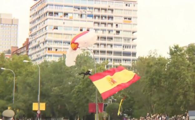 El paracaidista que portaba la bandera se queda enganchado en una farola