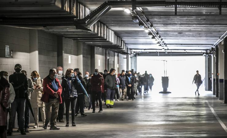 La fila del cribado, al resguardo de la lluvia en el aparcamiento del Riojafórum