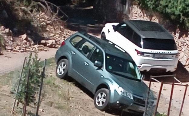 Coches aparcados en una zona verde en Canales de la Sierra