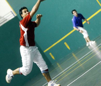 Camarero ejecuta un saque con AntxÃ­a al fondo. / JUSTO RODRÃGUEZ/